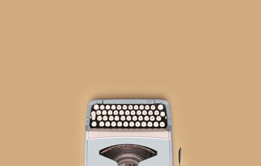 Overhead top view of a vintage aqua blue typewriter against a beige background