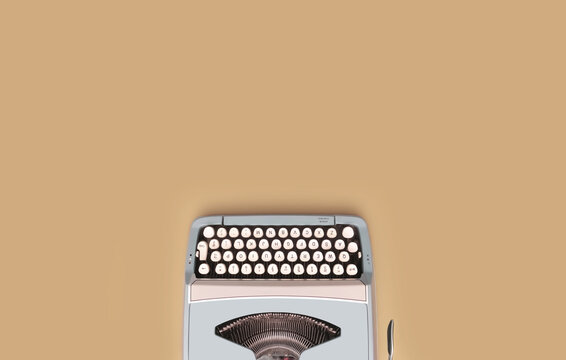 Overhead top view of a vintage aqua blue typewriter against a beige background