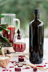  Beet kvass in a glass and mason jar with loose beets, side view, gray background