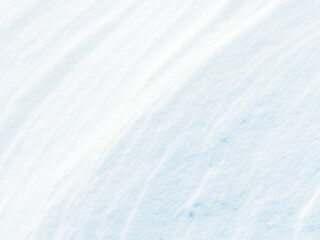 Beautiful winter background with snowy ground. Natural snow texture. Wind sculpted patterns on snow surface. Closeup top view with copy space.