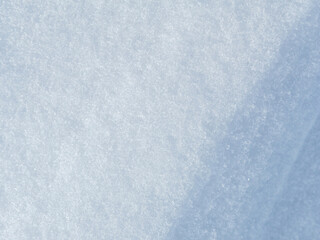 Obraz premium Beautiful winter background with snowy ground. Natural snow texture. Wind sculpted patterns on snow surface.