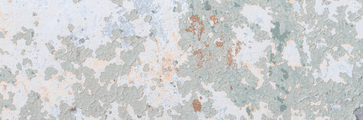 Peeling paint on the wall. Old concrete wall with cracked flaking paint. Weathered rough painted surface with patterns of cracks and peeling. Grunge texture for background and design. High resolution.