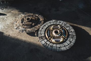 Clutch - new vs old part- old extremely torn out. medium closeup in garage shop. High quality photo