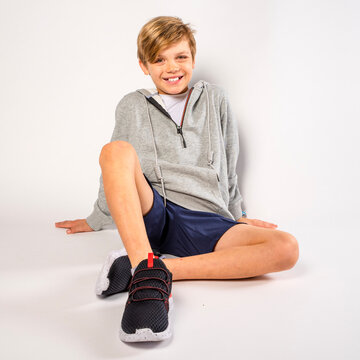 Happy young boy sitting on floor with a smiling expression