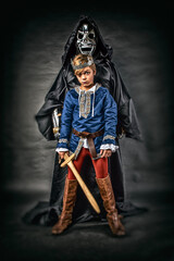 Young cosplay prince posing with sword in front of evil villain - obrazy, fototapety, plakaty