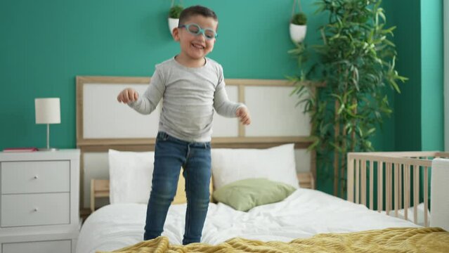 Woman And Toddler Smiling Confident Jumping On Bed At Bedroom