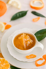 Fresh bitter orange marmalade with ripe fruit offered as closeup on a rustic black board with copy space