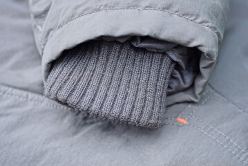 part of a gray winter jacket with one woolen sleeve
