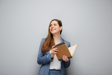Teacher holding open book and looking away.