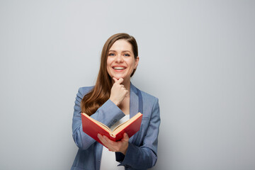 Fototapeta premium Thinking woman teacher or smiling student girl portrait with open red book..