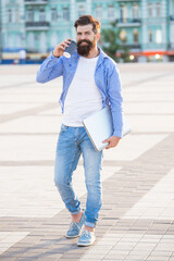 Fototapeta premium guy talk on smartphone walking in the street. photo of guy talk on smartphone.