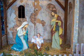 figures of the holy family - St. Mary, Joseph and the newborn baby Jesus in a manger in a...