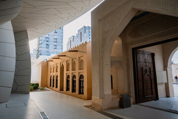 view from the interior national museum of qatar It shows an old gate and an old Qatari folk house,...