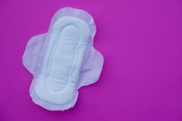 White sanitary pad 
on pink background. Concept: female's hygienic product for period's day. Protect from menstruation blood to stain underwear clothes. Woman healthcare. Intimate hygiene. Top view.