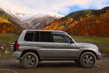 Fototapeta na wymiar Picturesque view of modern car in beautiful mountains on autumn day