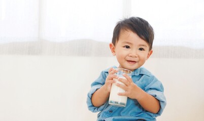 Boy drinking milk from glass And smiling happily, under the concept of drinking milk for good health.