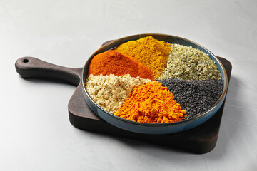 Plate with different spices on light grey table