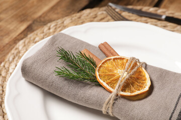 Beautiful dishware, fabric napkin and dried orange slice, closeup. Christmas table setting