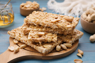 Delicious peanut bars (kozinaki) and ingredients on light blue wooden table