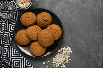 Delicious oatmeal cookies and flakes on grey table, flat lay. Space for text