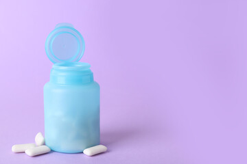 Jar with chewing gums on lilac background. Space for text