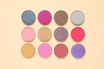 Different beautiful eye shadows on beige background, flat lay