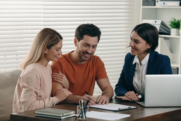 Man signing documents at wooden table in notary office
