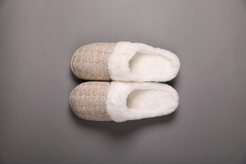 Pair of beautiful soft slippers on grey background, top view