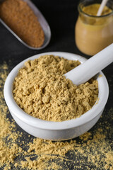 Mortar with mustard powder on black table