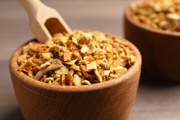 Bowls of dried orange zest seasoning on wooden table, closeup