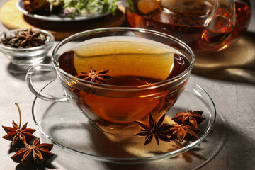 Aromatic tea with anise stars on light grey table, closeup
