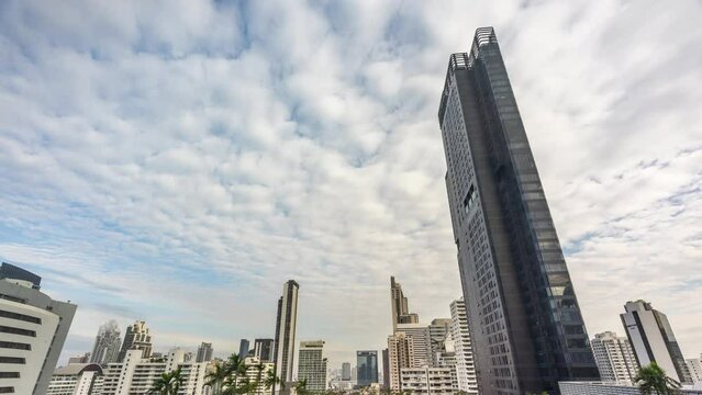 Time lapse view of Bangkok high-rises  on cloudy day with white clouds moving across the sky