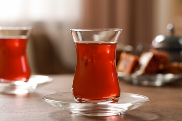 Glass of traditional Turkish tea on wooden table, closeup