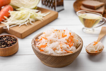 Bowl of tasty sauerkraut on white wooden table