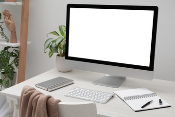 Comfortable workplace at home. Modern computer with blank screen and notebook on white desk. Mockup for design