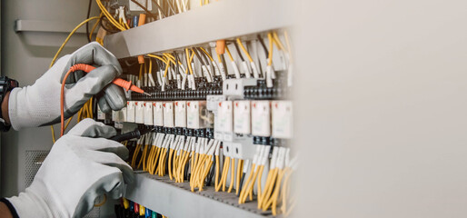 Electrician engineer tests electrical installations and wires on relay protection system.