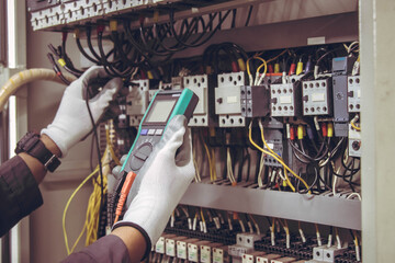 Electrician engineer tests electrical installations and wires on relay protection system.