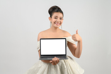 Obraz premium Young asian beautiful bride pose with mockup laptop computer in hand