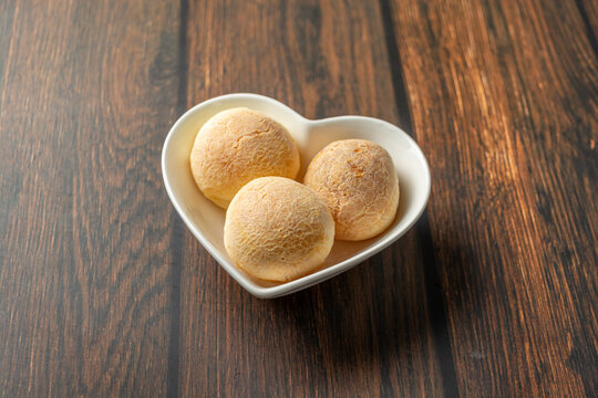 cheese bread in heart-shaped container on wooden table