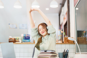 Coworking space office concept, Woman entrepreneur stretching arm to relax after completing meeting