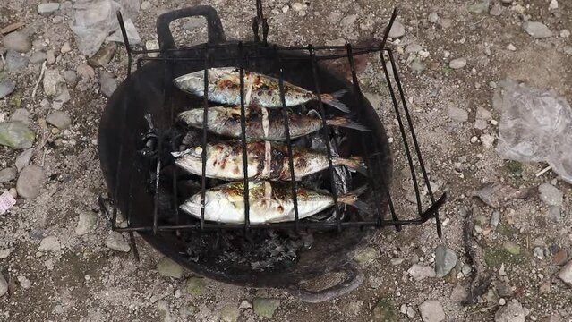 the process of making grilled fish that is burned over coconut shell coals