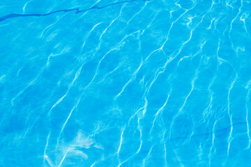 Abstract stylish texture of blue waves and highlights. Clean clear water of the pool. A stylish concept of relaxation in hotels and spas. Relaxing in the pool and relaxing for the family
