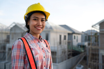 Portrait of young civil engineer worker work at real estate site background. Wear yellow helmet , reflective jacket for security protection and unexpected accident. Engineering, construction