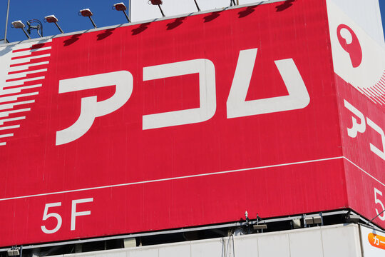 TOKYO, JAPAN - March 23, 2021: Acom, a consumer loan company, sign on a building in Tokyo's Ueno area.