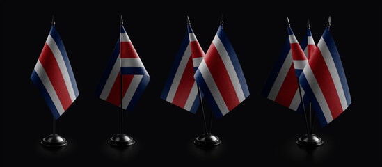 Small national flags of the Costa Rica on a black background