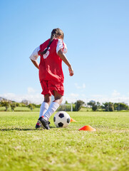 Sports, training and girl playing soccer for fitness, physical activity and hobby on a field in Spain. Active, focus and athlete dribbling a football for a game, cardio and match on the grass © Nina/peopleimages.com