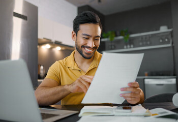 Planning, smile and Asian man with paperwork and a laptop for finance budget, entrepreneurship and tax. Happy, summary and freelancer reading the proposal of a project, financial deal or report - obrazy, fototapety, plakaty