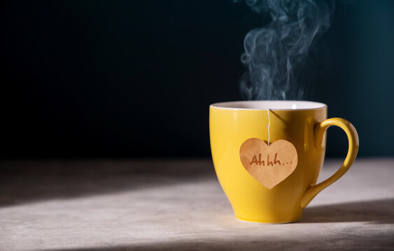 Tea Lover Concept. Eco-Friendly Style Tag made as Heart Shape and Hanging on Cup. Green, Oolong, Fermented, Organic, Healthy and Aromatic Tea. Warm Light shaded the Table