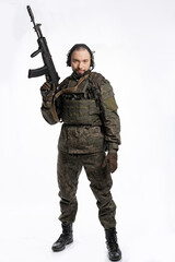 soldier in the studio on a white background. a man in military uniform with a rifle or machine gun. military or airball player