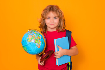 Isolated portrait of school child. School boy with world globe and book. Kid boy from elementary school. Little student, smart nerd pupil ready to study. Concept of knowledge, education and learning
